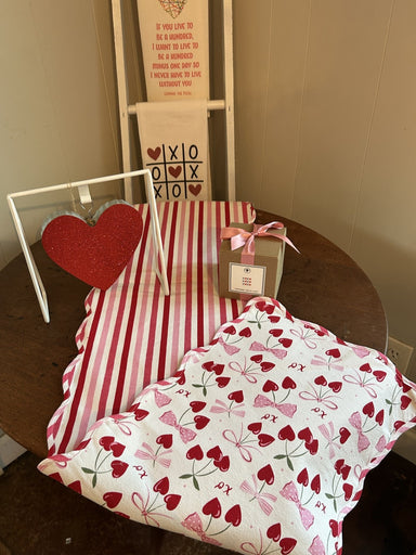 Celebrate love in style with this delightful reversible table runner that doubles your decorating options. One side showcases charming hearts, bows, and XOs, while the flip side reveals a complementary striped design—perfect for mixing up your Valentine's Day look throughout the season. The graceful scalloped edges add sophistication and whimsy, instantly elevating your tablescape with festive flair. Create an inviting, romantic atmosphere that makes every meal feel special and shows your guests how much yo