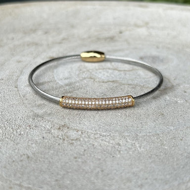 This mixed metal bracelet seamlessly blends gold and silver for a modern, versatile aesthetic. The striking cubic zirconia bar adds a touch of sparkle and sophistication to any wrist. The secure magnetic closure ensures effortless wear throughout your day, making it perfect for both casual and dressed-up occasions. A timeless piece that complements any style.

Note: Silver N' Accessories jewelry is brass and stainless steel with rhodium and 18 KT gold plated. It's water resistant and anti tarnish, but it's 