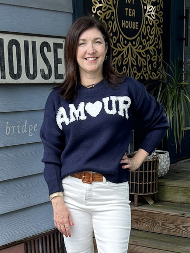 Wrap yourself in warmth and style with our "AM🖤UR" Long Sleeve Sweater Top. Featuring adorable lettering in white on a navy background, a crew neck, banded cuff and waist, this sweater is the perfect addition to your wardrobe. Stay cute and cozy in this must-have piece!

Material: 100% Acrylic

Care Instructions: Hand wash cold, line dry