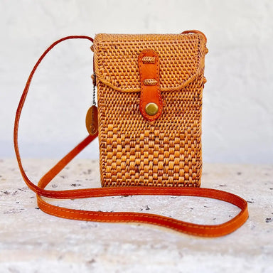 Handcrafted crossbody purse woven from natural ata vine and rattan in warm medium brown and rust tones. Perfectly sized to carry your cell phone, cards, and daily essentials while keeping your hands free. The adjustable strap makes it ideal for on-the-go wear, whether you're running errands or enjoying a casual day out. Each piece is uniquely made, showcasing the artisanal quality of traditional weaving techniques.

Dimensions: 5 x 2.5 x 8 in

Material: Ata Vine and Rattan, Leather Strap, Batik Print Lining