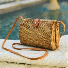 You will love this handcrafted ata vine and rattan crossbody purse featuring a charming teardrop silhouette. This versatile piece showcases warm medium brown and rust tones with natural texture throughout. Wear it as a clutch or adjust the crossbody strap for hands-free convenience. Secured with a reliable top snap closure, it's the perfect companion for everyday adventures or special occasions.

Dimensions: 8 x 6 x 3 in

Material: Ata Vine and Rattan, Leather Strap, Batik Print Lining (pattern varies)