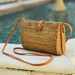 You will love this handcrafted ata vine and rattan crossbody purse featuring a charming teardrop silhouette. This versatile piece showcases warm medium brown and rust tones with natural texture throughout. Wear it as a clutch or adjust the crossbody strap for hands-free convenience. Secured with a reliable top snap closure, it's the perfect companion for everyday adventures or special occasions.

Dimensions: 8 x 6 x 3 in

Material: Ata Vine and Rattan, Leather Strap, Batik Print Lining (pattern varies)