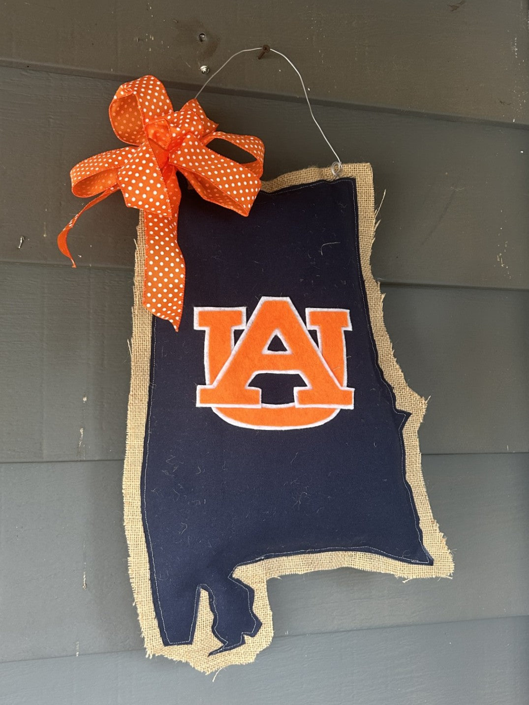 This state of Alabama Auburn themed doorhanger is made right here in Peachtree Corners by local textile artist, Allison Wright and provides an oh, so easy way to show support of your Tigers! Allison uses a combination of assorted burlaps, fabrics, ribbons and paints to produce her unique wreaths and door hangers. She has a background in art and has pursued her home business, Bopsidodle, while at home with her four sons. We love her and are happy to showcase her talent at Carolee's!