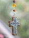 Carry your faith with you wherever the road takes you. This artisan cross car charm is hand-molded with care and features an adjustable length to fit any vehicle. A meaningful reminder of blessings and spiritual protection for daily journeys.

Dimensions: 4.5in L beaded strand, 2.5in L x 1.75in W cross, 12in faux leather strand

Material: Cross: terra cotta, Beads: glass &amp; acrylic