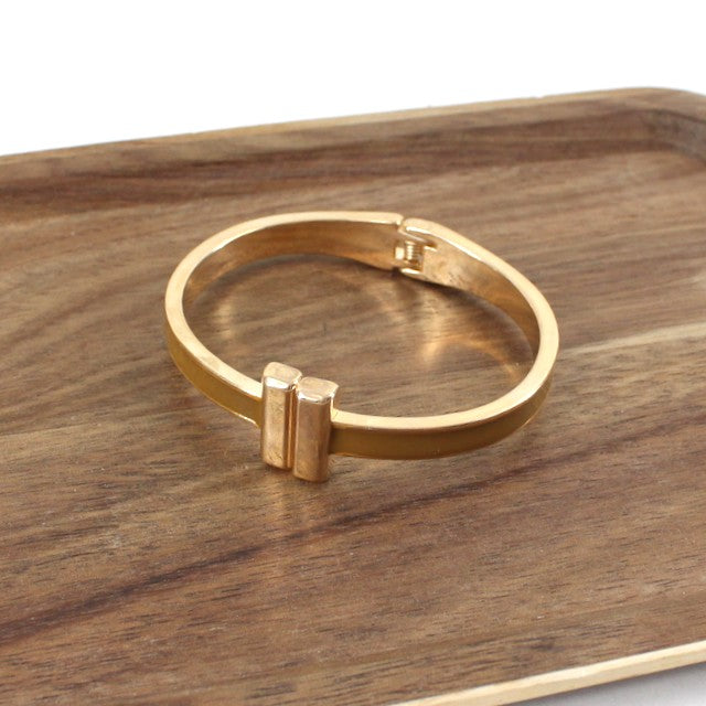 This Color Band Hinged Bracelet is the perfect blend of sleek, modern style and practicality. Its subtle brown and gold hue and catches the light beautifully while the smooth hinged closure ensures a secure fit that's easy to put on and take off. Layer it with complementary pieces for maximum impact, or let it shine as a standalone statement.&nbsp;
