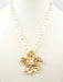 Make a graceful statement with this exquisite freshwater pearl necklace, showcasing a handcrafted gold hammered flower pendant. The lustrous pearls provide a soft, luminous quality, while the textured metalwork adds sophisticated dimension. Whether you're dressing for an evening event or elevating your everyday elegance, this piece delivers timeless appeal.

Length: 16-18"