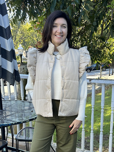 Stay cozy while making a statement in our Beige Puffy Vest with Side Pockets. This stylish piece features a snap front closure, ruffled cap sleeve, and a mock neck for an extra layer of warmth. Perfect for chilly days, this great transition piece is also so cute for football games and outdoor events! Don't miss out on this must-have item!  Material: 100% Polyester; Lining: 100% Nylon  Care Instructions: Hand wash in cold water, line dry
