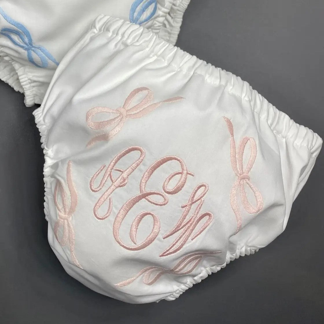 These charming baby bloomers (or diaper cover) feature four delicate bows and offer the perfect canvas for personalized monogramming. Ideal for newborn photography sessions, they elegantly conceal the diaper while adding a touch of sweetness to every shot. Add a custom monogram to create a truly one-of-a-kind keepsake that captures those precious early moments in style.&nbsp;

Details:

Size: 0-12 Months
White w/ Bow Trim
Looks precious with a monogram on the back.
Material: 100% Cotton - Handmade
Machine W