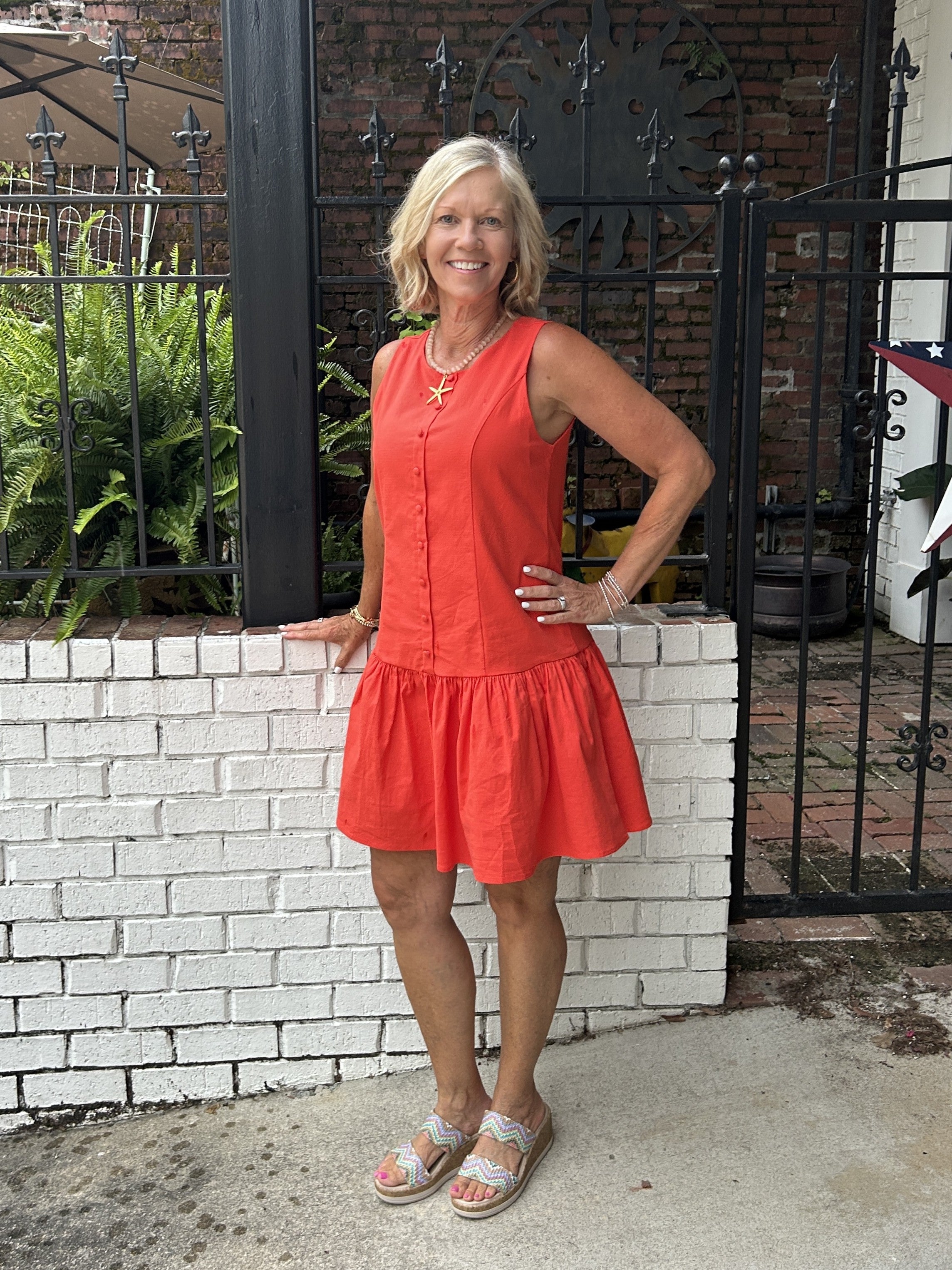 You will love our vibrant orange sleeveless dress featuring a charming drop tier skirt and faux button front detail. Lined for comfort with a back zipper for easy wear. Versatile enough for game day casual paired with sneakers, or elevated with sandals and accessories for a polished look. Perfect for spring and summer occasions. Pair with a skinny scarf or denim jacket for cool evenings.


Barbara is wearing a Small.

Material: 95% Cotton / 5% Spandex; Lining: 100% Polyester

Care Instructions: Gentle cool 