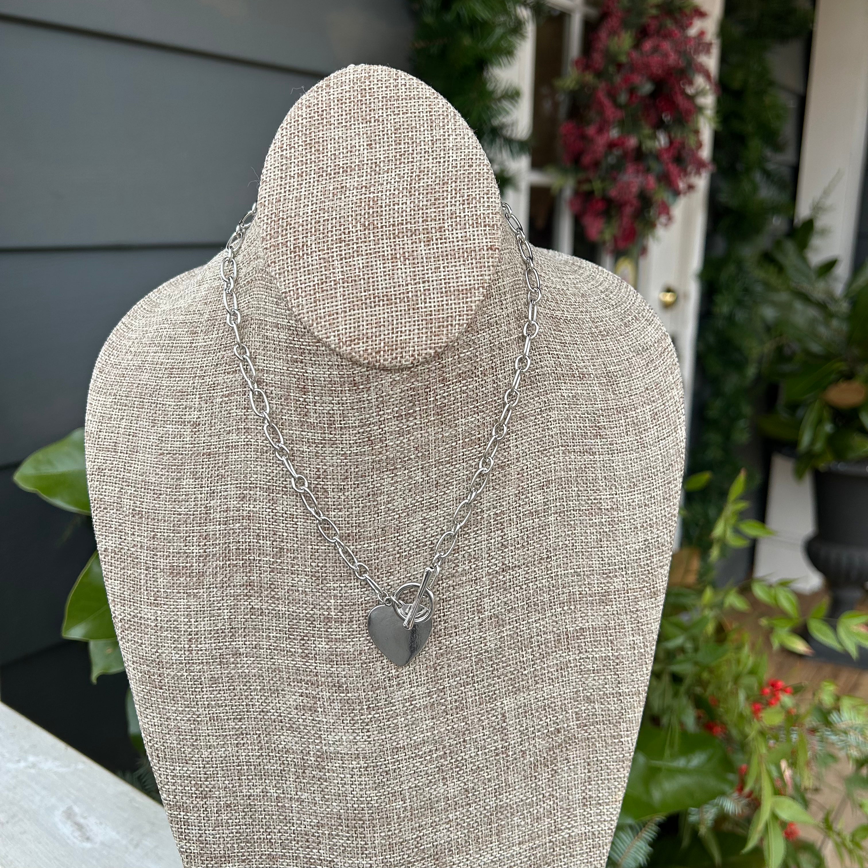 Look stylish in this gorgeous Short Silver Necklace with Heart Pendant. Its beautifully crafted solid heart pendant and T-bar clasp combine for a contemporary take on classic elegance. Add the perfect finishing touch to your outfit!  Approximate length: 17"