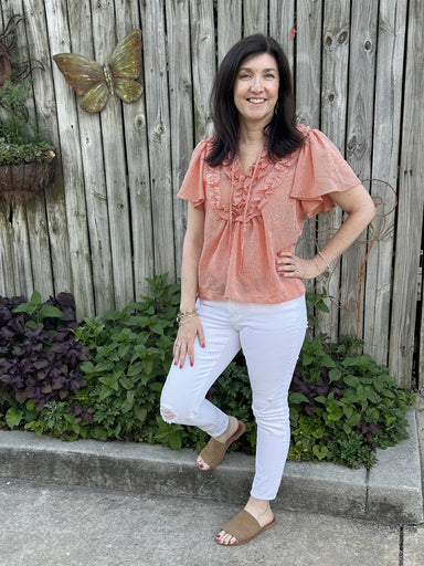 This flutter sleeve striped top in burnt orange is the perfect transitional piece from summer to fall. It features a beautiful ruffled front and a tie at the neck. Pair it with your favorite white jeans or shorts for a stylish and effortless look.  Material: 100% Polyester  Care Instructions: Gentle cool hand wash, dry flat