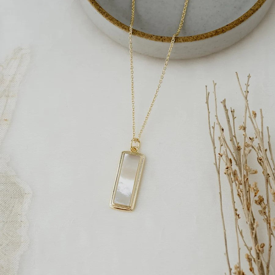 Introducing our Serephina Necklace, featuring a stunning mother of pearl stone on a bar drop. With its classic design, this necklace is a wonderful addition to any collection and is sure to add a touch of elegance to any outfit.  Details:  approx. 17" long chain, with 3" extender, approx. 1." long pendant made with mother of pearl silver or gold plated  hypoallergenic, nickel/lead free anti-tarnish coated