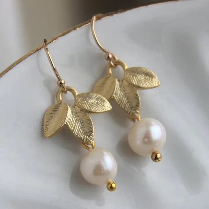 Elegant drop earrings featuring lustrous freshwater pearls with warm gold leaf accent. These timeless pieces combine natural pearl beauty with refined metalwork, perfect for adding a touch of sophistication to any occasion. Lightweight and comfortable for all-day wear.