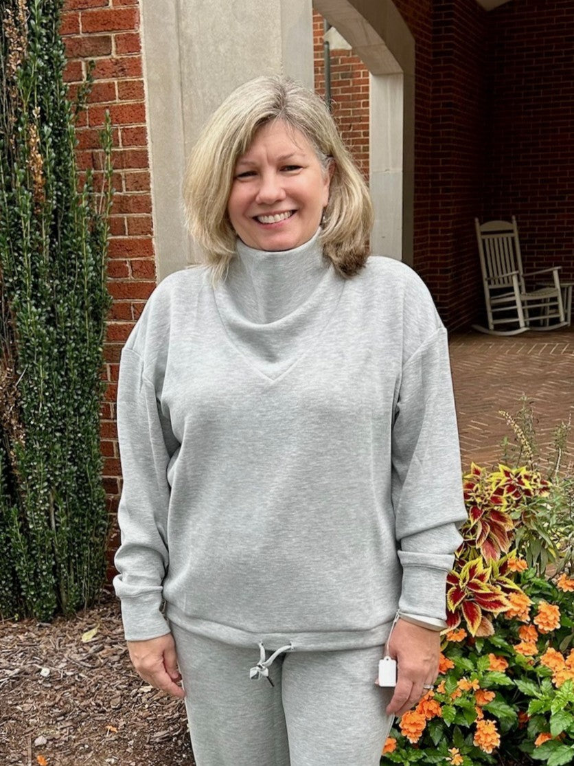 Experience ultimate comfort with this Heather Gray Cowl Neck Sweatshirt. Crafted from irresistibly soft material, it’s perfect for cozy days. The adjustable drawstring bottom allows you to cinch the fit for added warmth and style. Whether lounging or out and about, this sweatshirt combines casual ease with a flattering silhouette you'll love.

Pair with our matching "Jogger Pants".

Paula is wearing a size Medium.

Material: 48% Modal / 48% Polyester / 4% Spandex

Care Instructions: Hand wash separately in 