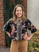 This blouse features a striking black background adorned with vibrant stripes and floral patterns, creating a unique and eye-catching look. Designed with elegant elbow-length puffed sleeves, it offers a flattering silhouette. The elastic neckline and waist ensure a comfortable, tailored fit, while the flowy, lined fabric adds a lovely drape and softness.

Barbara is wearing a size Small.

Material: 71% Rayon / 29% Nylon

Care Instructions: Gentle cool hand wash, dry flat