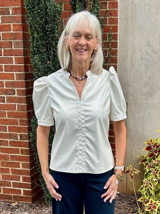 This cream-colored faux leather top combines softness with style, featuring a flattering V-neck and elegant gathered sleeves. Its dressy design creates a beautiful, polished look that’s perfect for any outfit.

Jodi is wearing a size Small.

Material: 100% Polyurethane

Care Instructions: Hand wash separately in cold water, lay flat to dry