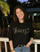 Celebrate the season in style with this black long sleeve sweater featuring elegant gold "Cheers" script across the front. Lightweight and comfortable, it’s perfect for festive gatherings without feeling bulky. Add a touch of holiday cheer to your wardrobe with this fun yet chic sweater that effortlessly combines comfort and festive flair.

Material: 61% Polyester / 15% Acrylic / 15% Nylon / 6% Wool / 3% Spandex

Care Instructions: Hand wash cold, line dry