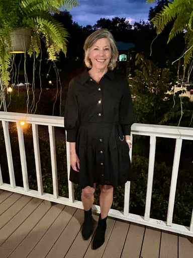 This black, collared dress offers a sophisticated look with its stylish front placket and button-up design. Featuring mid-length sleeves, a flattering sash belt, and a tiered skirt, it effortlessly combines elegance with comfort for any occasion.

Material: 60% Cotton / 36% Polyester /&nbsp; 4% Spandex

Care Instructions: Gentle cool hand wash, dry flat