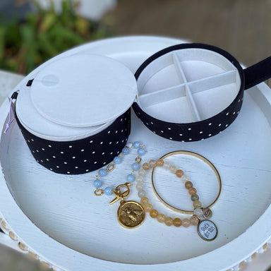 The Black Polka Dot Jewelry Round is an ideal way to store and organize jewelry. It features 1 large compartment, plus 3 smaller compartments for smaller items. The classic black polka dot pattern is sure to complement any décor.  Jewelry sold separately.