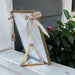 This stylish easel is perfect for showcasing items with a classic touch. Crafted from luxurious brass and glass, it is small and elegant enough to fit into any room. Display artwork, photos, and more with a unique and timeless look.  Pair this beautiful easel with our Calendar Inserts and Brass & Glass Frame. Calendar Inserts and Frame sold separately.  Dimensions 2 x 2 x 2.75 in.