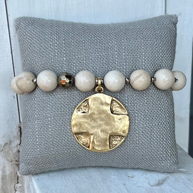 These bracelets are made of colored beads, separated by small gold dividers and features a hammered gold charm. The pendant has a cross on one side and the Lord's Prayer on the other.&nbsp;  The bracelet is handmade by an artisan in Atlanta, Georgia and will stretch to comfortably fit most wrists.&nbsp;