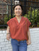 Embrace the season with this charming V-neck top in a rich rust hue, perfect for fall. Featuring delicate cap sleeves and gathered shoulders, it offers a flattering silhouette that enhances your natural shape. Lightweight and stylish, this top effortlessly combines comfort with seasonal elegance.

Tara is wearing a size Small.

Material: 100% Cotton

Care Instructions: Hand wash cold, do not tumble dry
