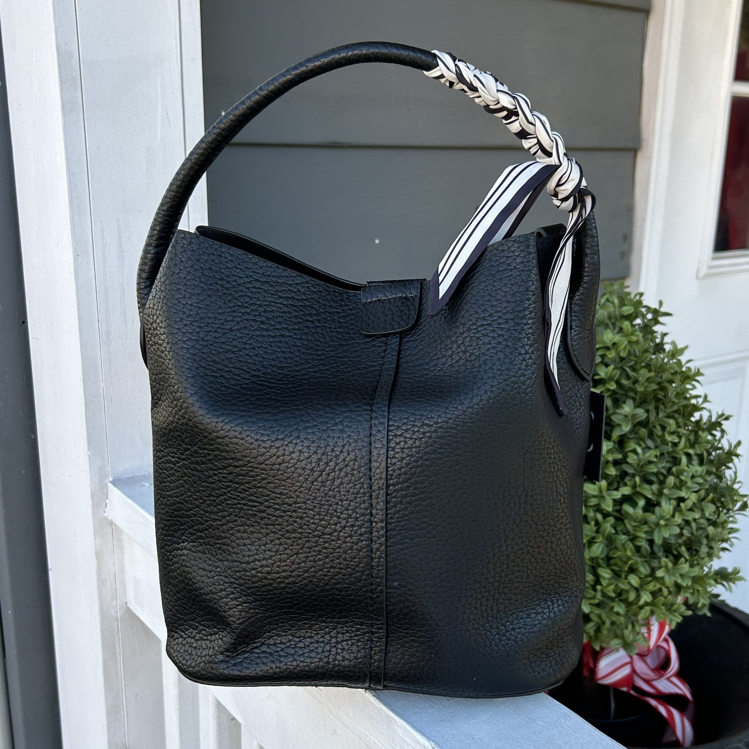 Discover the perfect blend of style and functionality with this Large Bucket Bag, featuring premium vegan leather in a refined pebbled texture. Designed for modern living, it includes a compact zippered pouch for extra organization and two carrying options—a short handle for hand-carry elegance or a cross-body strap for effortless mobility. The signature scarf accent brings a touch of sophistication, while the magnetic closure ensures your valuables stay secure throughout your day.

Dimensions: 9 x 6.5 x 5 