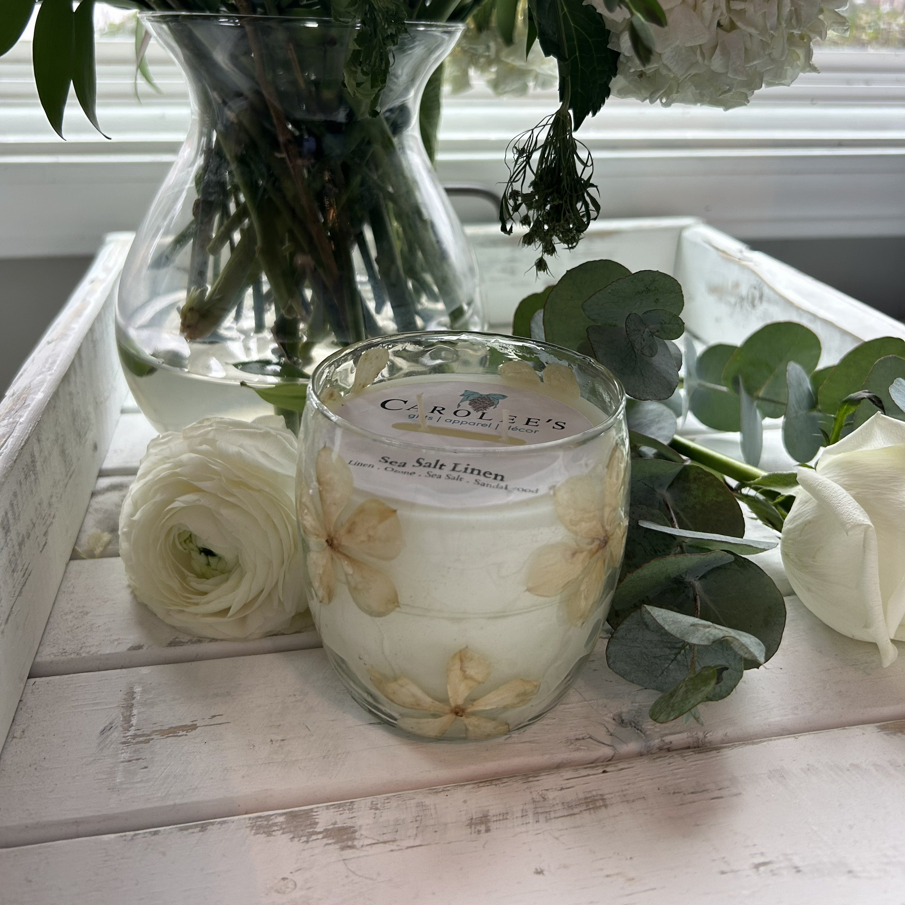Immerse yourself in the serene essence of sea salt and linen with this elegant 10 oz candle. Housed in a beautiful glass container adorned with delicate flower petals, it brings a touch of natural sophistication to any room. Perfect for creating a calming atmosphere, this fragrance blend evokes the freshness of coastal breezes and crisp linens, making it an ideal choice for relaxation or thoughtful gifting.