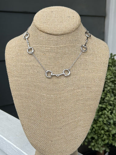 This refined short necklace showcases an elegant silver chain paired with distinctive equestrian boot charms that capture the spirit of horsemanship. The delicate design sits perfectly at the collarbone, making it an ideal accessory for riders, ranch enthusiasts, and anyone who loves western heritage. Wear it solo for subtle sophistication or layer it with other pieces for a personalized look.

Approximate Length: 15-17"

Note: Silver N' Accessories jewelry is brass and stainless steel with rhodium and 18 K