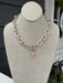 This mixed metal chain link necklace combines understated sophistication with everyday versatility. Two cross charms dangle gracefully from uniquely textured chain links, creating visual interest that works with any outfit. The T-bar closure provides secure, comfortable wear, while the mixed metal finish ensures effortless coordination with your existing jewelry collection. Perfect for layering or wearing solo, this piece brings timeless charm to any ensemble.