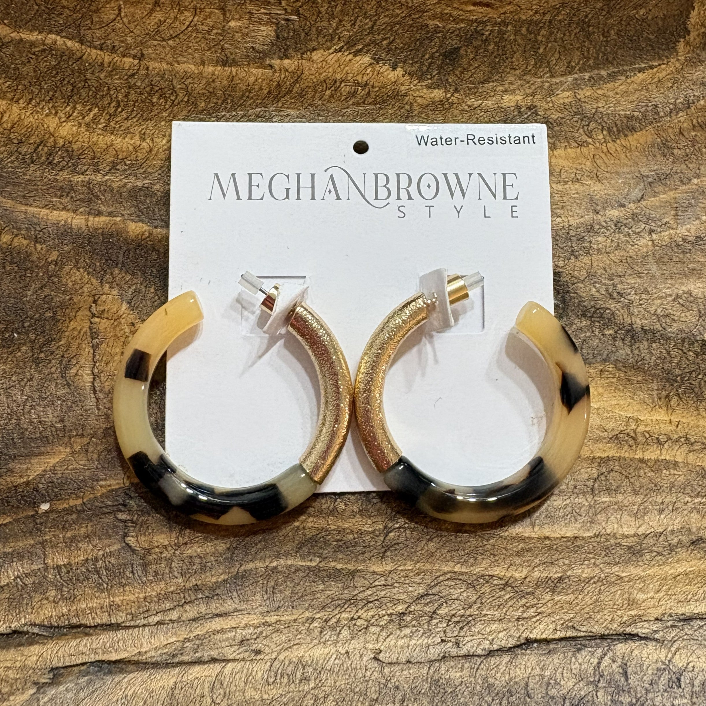 These Tortoise &amp; Gold Hoop Earrings are your go-to accessory for any occasion. Designed with a timeless aesthetic, they work beautifully for evening events, casual outings, and everything in between. The post-back closure provides secure, comfortable wear all day long. With their striking black and gold finish, these hoops add instant polish to your look while remaining a versatile wardrobe essential that pairs with virtually any style. Great for game day too!