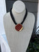 This is a striking black necklace featuring a gold hammered pendant and distinctive multi-rope chain design. Perfect for game day or any occasion where you want to make a bold statement. The textured pendant adds dimension and elegance to any outfit.