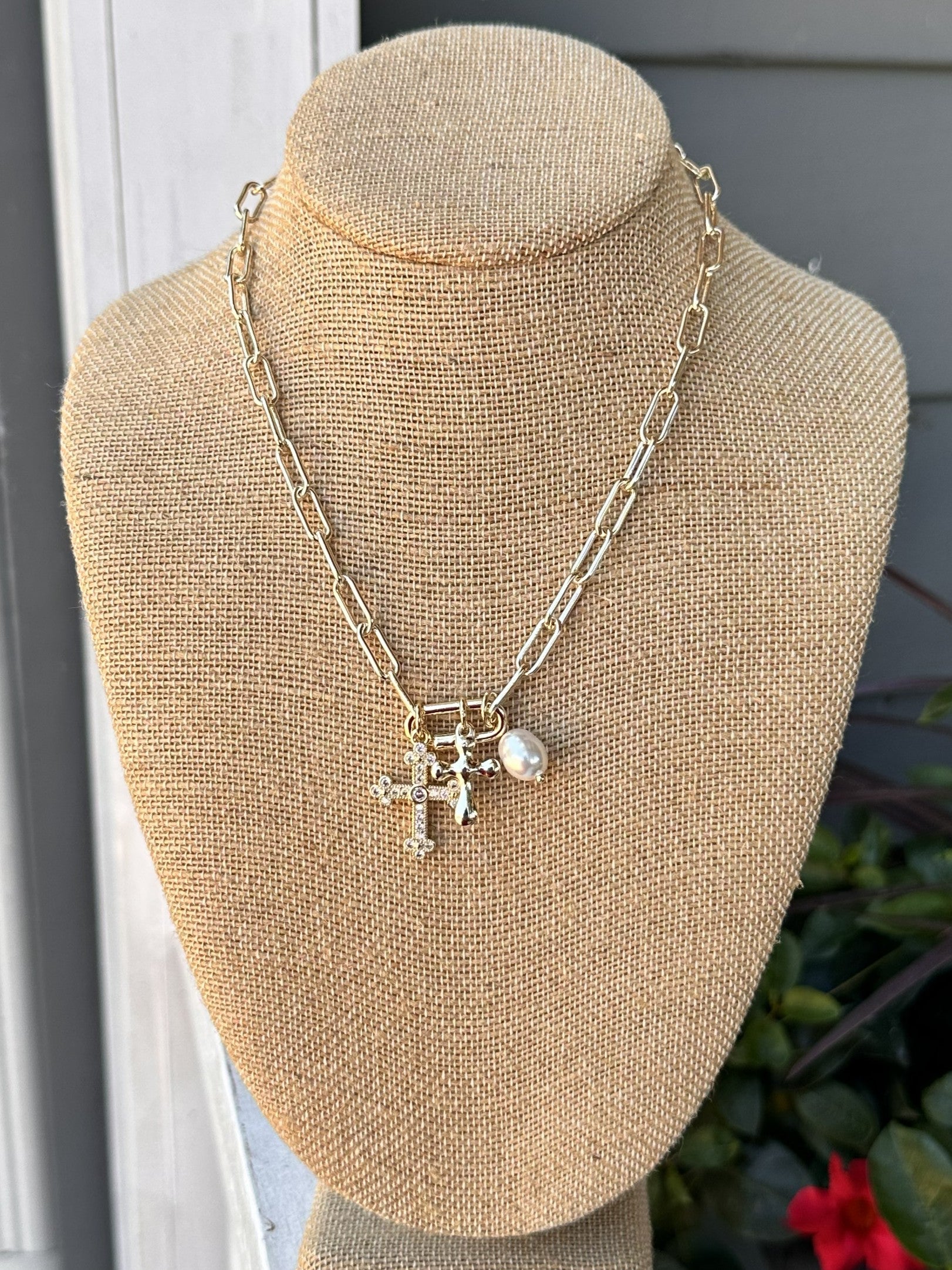 Add a touch of elegance to any outfit with our Gold Necklace w/ Cross &amp; Pearl Charms! This chain necklace features a stunning crosses and pearl charms, making it the perfect statement piece for any occasion – dressy or casual.

Approximate length: 17-19"