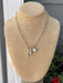 Add a touch of elegance to any outfit with our Gold Necklace w/ Cross &amp; Pearl Charms! This chain necklace features a stunning crosses and pearl charms, making it the perfect statement piece for any occasion – dressy or casual.

Approximate length: 17-19"