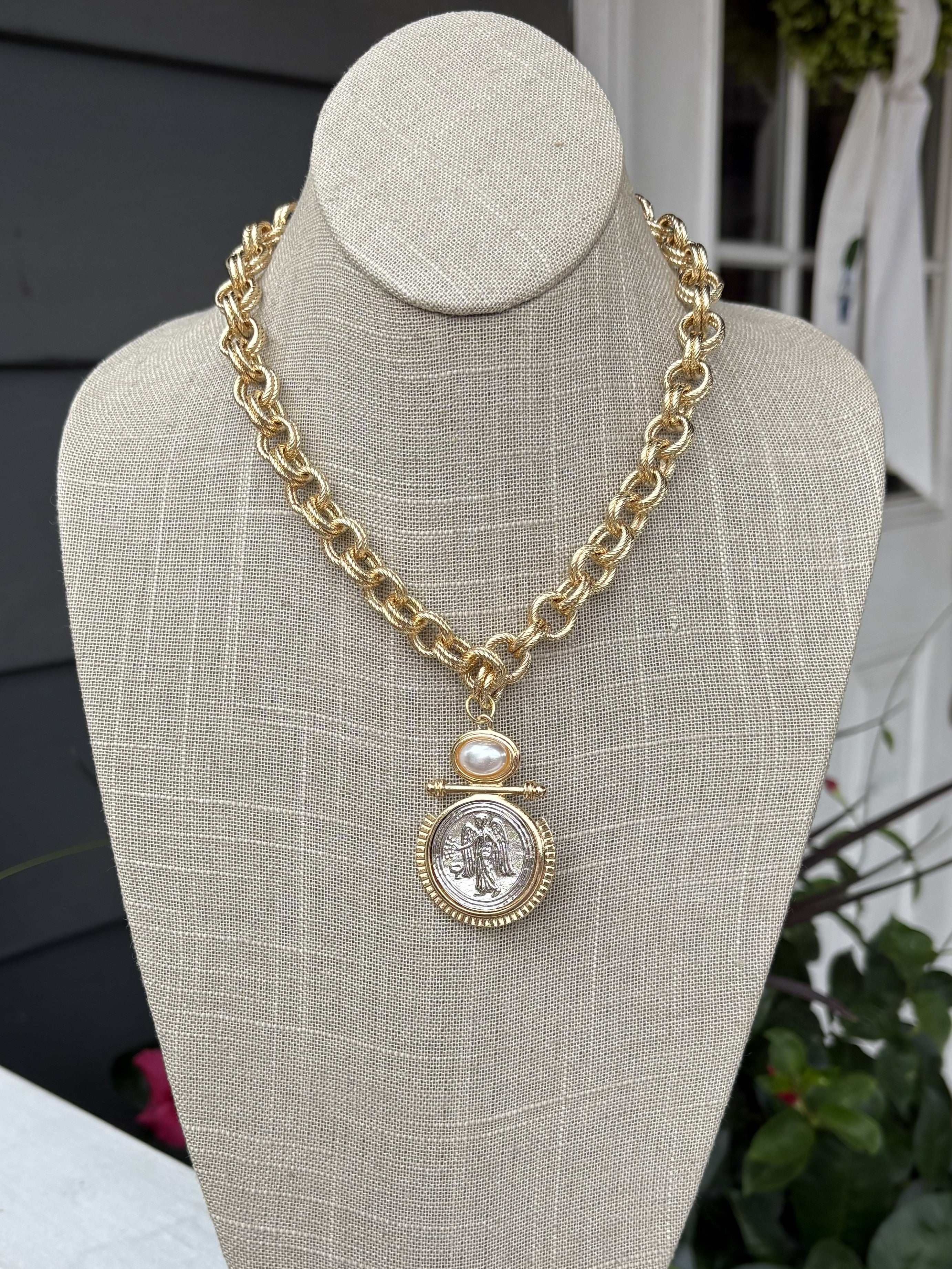 This timeless gold braided necklace combines refined elegance with versatile style. The delicate braided chain showcases expert craftsmanship, while the gleaming coin pendant adds a sophisticated focal point that works beautifully with any look. This necklace transitions seamlessly from day to evening wear. An essential jewelry staple that brings understated luxury to your collection.

Approximate length: 10-20"