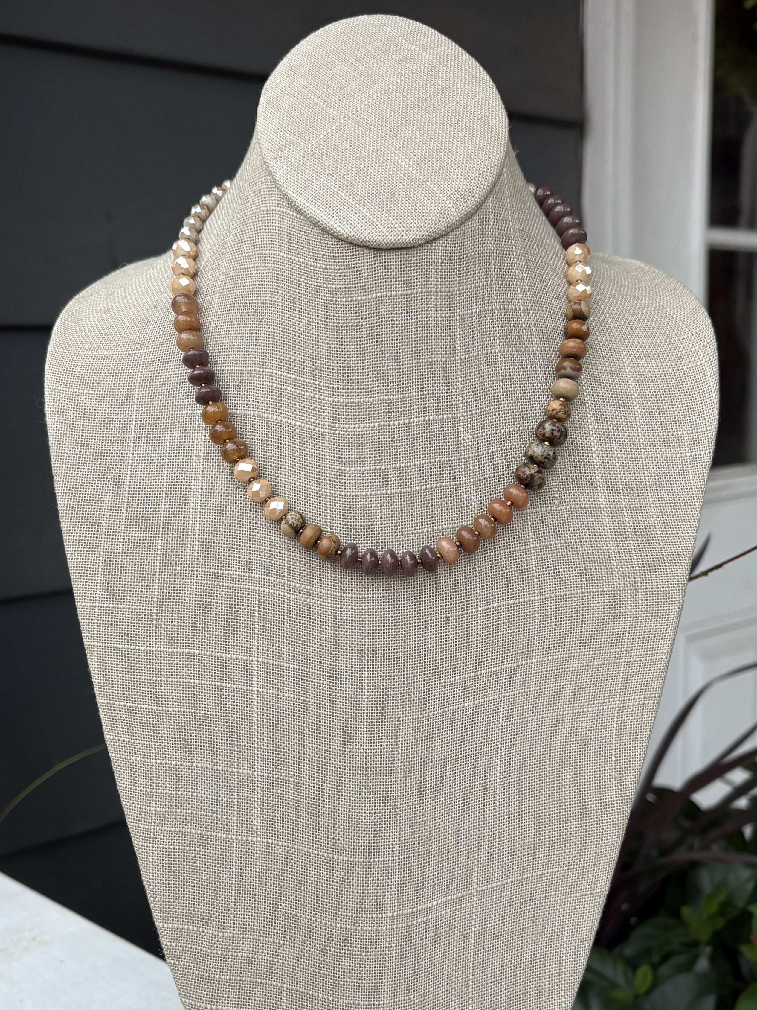 This elegant beaded necklace showcases a harmonious palette of warm brown and beige tones, expertly arranged in graduated sizes for visual interest and dimension. The thoughtfully designed shorter length makes it ideal for layering with other pieces or wearing as a standalone statement. Each bead is selected to create a cohesive, sophisticated look that works beautifully with any skin tone. Perfect for adding warmth and texture to both casual and dressed-up outfits, this versatile piece is a timeless additi