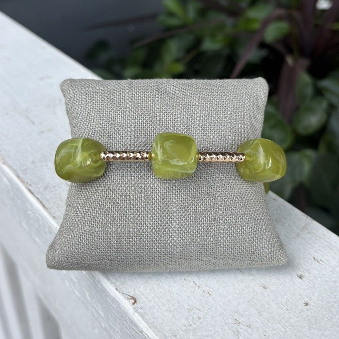 Olive green beads paired with shiny gold accents create a simple, stylish bracelet. Cube-shaped details and delicate gold beads add texture and interest, while the earthy green works with any skin tone. Wear it alone for a classic look or stack it with other bracelets. Perfect for everyday wear or dressing up for special occasions.

Water resistant.