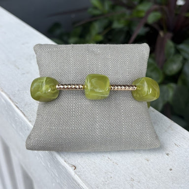Olive green beads paired with shiny gold accents create a simple, stylish bracelet. Cube-shaped details and delicate gold beads add texture and interest, while the earthy green works with any skin tone. Wear it alone for a classic look or stack it with other bracelets. Perfect for everyday wear or dressing up for special occasions.

Water resistant.