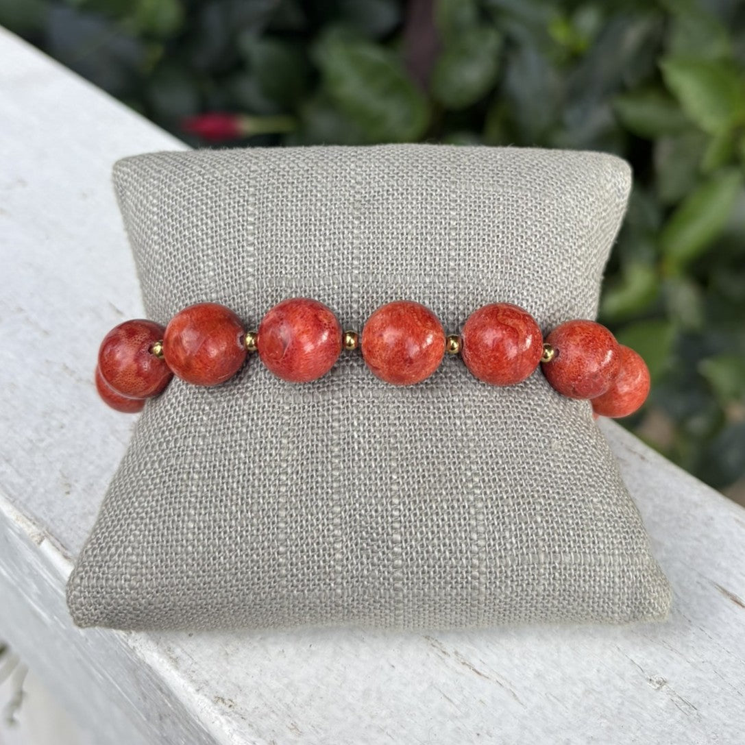 Elegant stretch bracelet featuring rich dark coral beads beautifully accented with gleaming gold beads. The comfortable stretch design slips on effortlessly for everyday wear or special occasions. A timeless piece that adds warmth and sophistication to any jewelry collection.