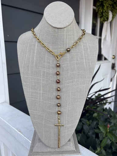 Enhance your everyday style with this striking Gold &amp; Copper Long Cross Necklace. The elongated cross pendant commands attention while maintaining a versatile neutral aesthetic that pairs effortlessly with any outfit. Crafted with a delicate gold chain adorned with warm copper bead accents, this piece offers visual depth and dimension. The adjustable length ensures a perfect fit for every neckline, while the secure lobster claw closure provides reliable wear day after day. A timeless accessory that brid