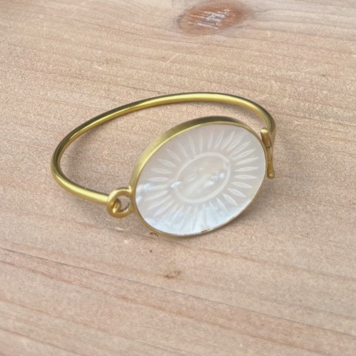 Up your style with the Zahara Brass Hinge Bracelet! Made of brass, this hinged bracelet features a stunning mother of pearl sunburst accent. Perfect for any occasion, it effortlessly adds a touch of elegance to any outfit. 