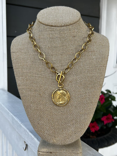 Introducing our new, unique Oval Chain Necklace featuring a stunning coin pendant. The beautiful gold chain with T-bar closure creates a luxurious foundation for the coin pendant. Perfect for adding a touch of bold elegance to any outfit.

Approximate length: 19"