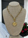 Introducing our new, unique Oval Chain Necklace featuring a stunning coin pendant. The beautiful gold chain with T-bar closure creates a luxurious foundation for the coin pendant. Perfect for adding a touch of bold elegance to any outfit.

Approximate length: 19"