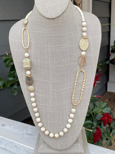 Treat yourself to something special with this Elegant Ivory and Gold Long Necklace. Show off your classy style with a combination of ivory beads and gold oblong pieces, plus a few neutral stones. Perfect for formal occasions, this necklace will have you looking so elegant!  Approximate length: 38-41"