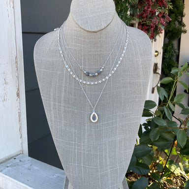 Featuring a triple strand design, this necklace grants you the freedom to combine layers of fashion to create your own look. The multiple lengths look great alone or when they're all worn together. One strand has three gray beads while the longest one has a pear-shaped pendant! Enjoy a fresh and creative style every day.  Length is approximately 14-19"