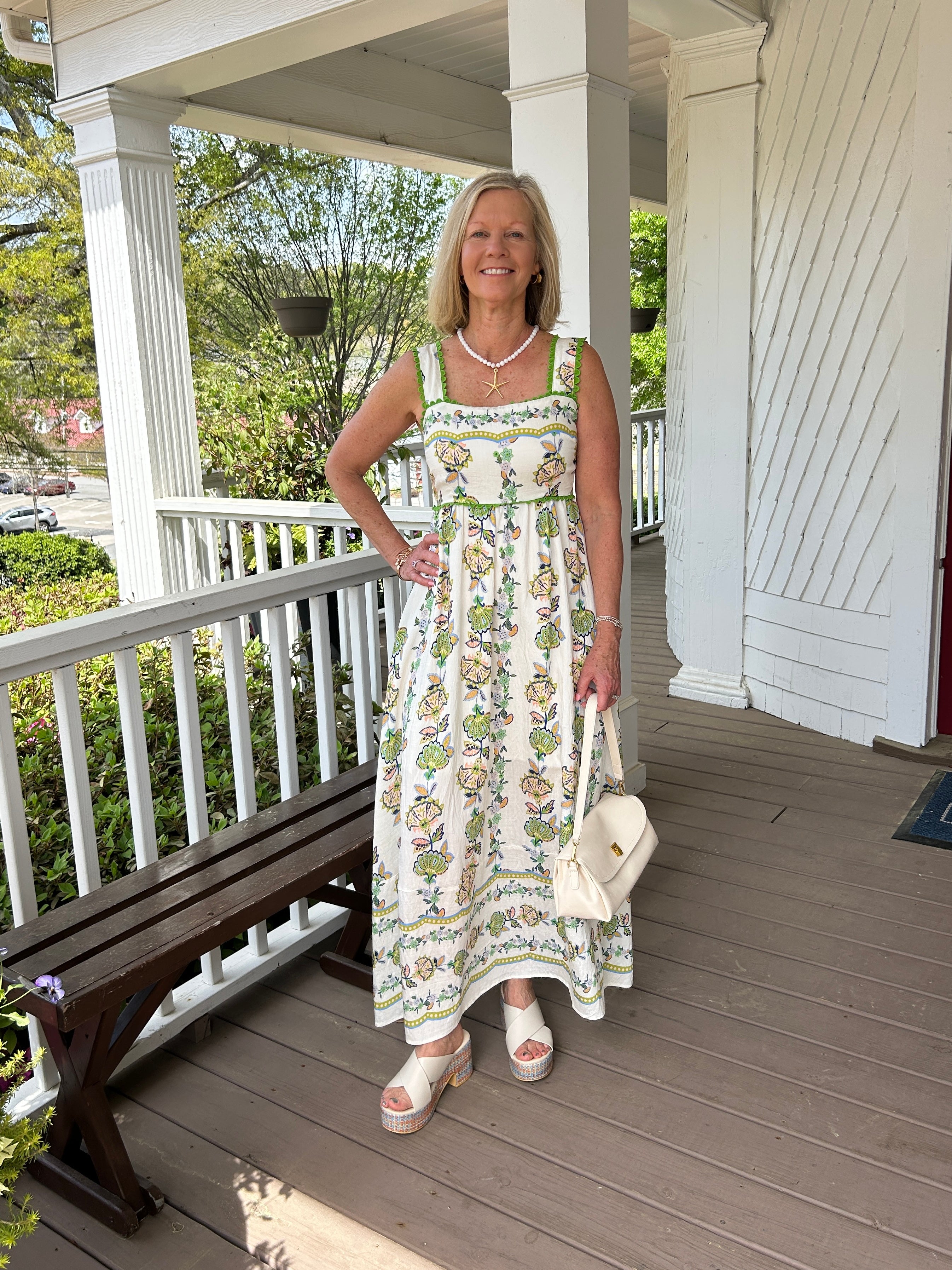 This lovely sleeveless maxi dress brings effortless elegance to your warm-weather wardrobe. Showcasing a beautiful floral print with charming green scalloped trim detailing, the layered tiered skirt creates a flattering silhouette with graceful movement. Whether you're heading to the beach or enjoying a summer gathering, this versatile piece transitions seamlessly from day to night. The soft rayon and polyester blend ensures comfort and breathability, while the interior lining provides coverage and ease of 