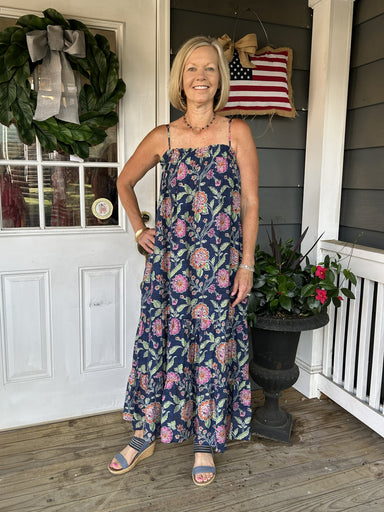 Escape to effortless summer style with this enchanting spaghetti strap maxi dress. Delicate florals dance across a sophisticated navy background, creating a look that's both romantic and refined. The gracefully tiered skirt adds movement and dimension, while hidden side pockets and a lined skirt offer practical elegance. Perfect for beach days, garden parties, or any occasion calling for breezy sophistication. Slip it on and feel the difference quality craftsmanship makes.

Material: 80% Rayon / 20% Nylon

