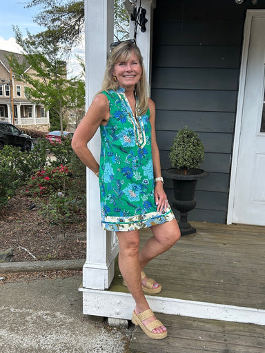 Discover the perfect dress that seamlessly transitions from day to night with its captivating design. This sleeveless floral print dress showcases a gorgeous kelly green foundation that beautifully complements the intricate blue floral motif throughout. The cream print front placket and hemline provide an elegant contrast that elevates the entire look with refined detail. Whether you're heading to the office, a garden party, or a weekend getaway, this dress delivers both comfort and undeniable style. The br