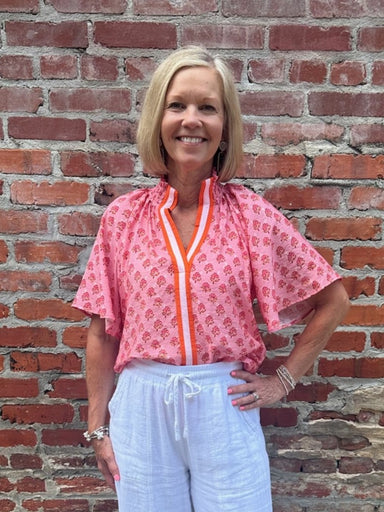 A vibrant blend of pink and orange creates an eye-catching color story on this versatile summer essential. The ruched collar adds textural interest and a polished touch, while the contrasting front pocket brings playful detail. Style it tucked or untucked for effortless day-to-night versatility. Perfect for warm-weather dressing with an instant pop of color.

Barbara is wearing a size XSmall.

Material: 85% Rayon / 15% Linen

Care Instructions: Gentle cool hand wash cold, dry flat