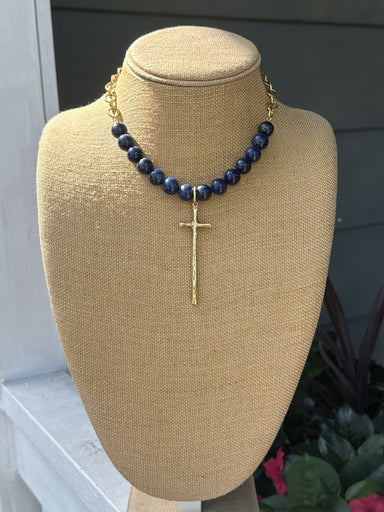 Elegant bead and chain necklace featuring rich lapis beads paired with delicate open gold chain. The centerpiece showcases a long, hammered cross pendant with beautiful texture and dimension. A sophisticated piece that combines natural stone beauty with refined metalwork for a timeless look.

Approximate length: 19-21"